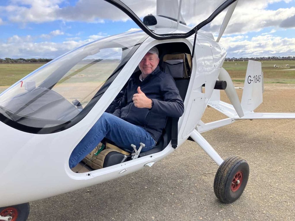 A person putting thumbs up after flight in an enclosed gyroplane